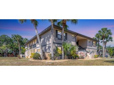 Charming condo exterior with well-kept landscaping, palm trees, and covered entrance at 19505 Quesada Ave # Qq101, Port Charlotte, FL 33948