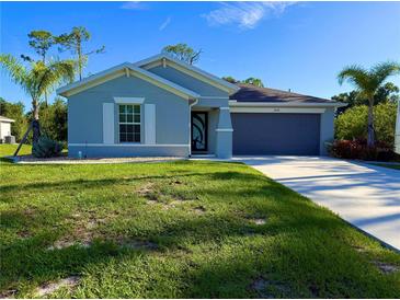 Charming single-story home with blue siding, well-manicured lawn, and a two-car garage at 21310 Quesada Ave, Port Charlotte, FL 33952