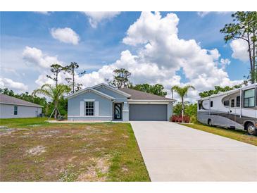 Attractive single-story home with a two-car garage and a pristine front lawn at 21310 Quesada Ave, Port Charlotte, FL 33952