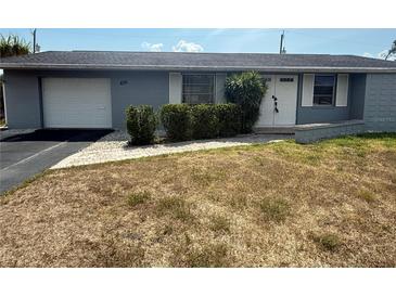 Charming single-story home features a well-manicured lawn, attached garage, and inviting front entrance at 635 W Tarpon Nw Blvd, Port Charlotte, FL 33952