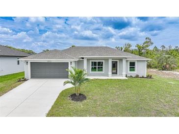 Charming single-story home with a well-manicured lawn, gray exterior, and a two-car garage at 13972 Chesswood Ln, Port Charlotte, FL 33981