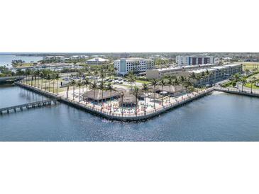 Aerial view of waterfront entertainment venue with tiki huts and colorful seating near hotels and the harbor at 150 Harborside Ave # 306, Punta Gorda, FL 33950
