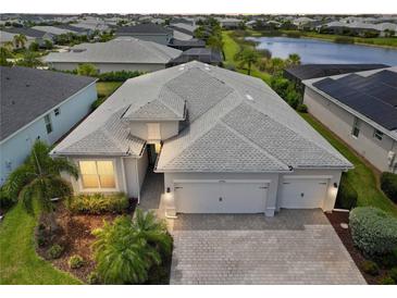 Beautiful aerial view of home, showcasing the three-car garage, paver driveway and landscaping at 17556 Winding Wood Ln, Punta Gorda, FL 33982