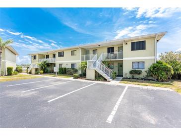 Inviting two-story condo featuring stairways leading to upper-level units and well-manicured landscaping at 25225 Rampart Blvd # 1603, Punta Gorda, FL 33983