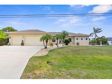 Charming single-story home featuring a spacious three-car garage, lush lawn, and inviting curb appeal at 2911 Riverside Dr, Punta Gorda, FL 33950