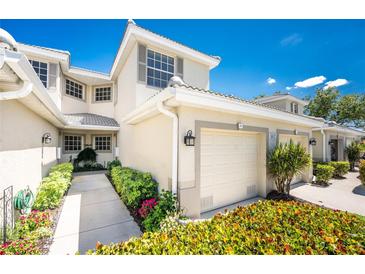 Inviting two-story townhome features a private garage and beautifully landscaped walkway at 3412 Grand Vista Ct # 202, Port Charlotte, FL 33953