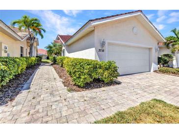Beautiful home showcasing a brick driveway, lush greenery, and attached garage at 3715 Albacete Cir # 93, Punta Gorda, FL 33950