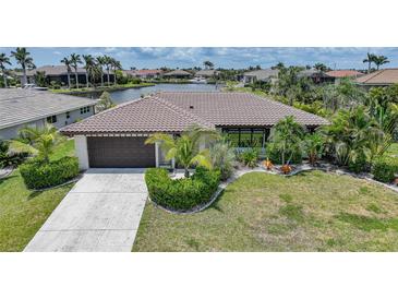 Charming single-story home with a tile roof, lush landscaping, and waterfront views at 376 Portofino Dr, Punta Gorda, FL 33950