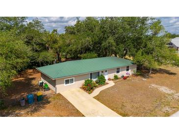 Charming single-story home with a well-manicured lawn and a green metal roof at 4009 Yucatan Cir, Port Charlotte, FL 33948
