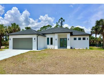 This home has a 2 car garage and a manicured lawn at 2743 Begonia Ter, North Port, FL 34286