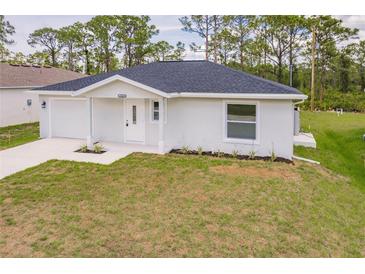 Charming single-story home featuring a well-manicured lawn and a cozy, covered entryway at 27438 Corinthian Dr, Punta Gorda, FL 33955