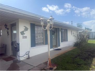Charming single-story home with blue shutters, manicured lawn, and decorative fish accents at 330 Lasayette Ne Dr, Port Charlotte, FL 33952