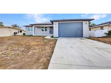Charming single-story home featuring a new driveway and attached one car garage at 3380 Elkcam Blvd, Port Charlotte, FL 33952