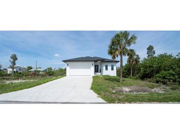 Beautiful single-story home featuring a pristine white exterior and a spacious driveway at 3920 Wisteria Pl, Punta Gorda, FL 33950