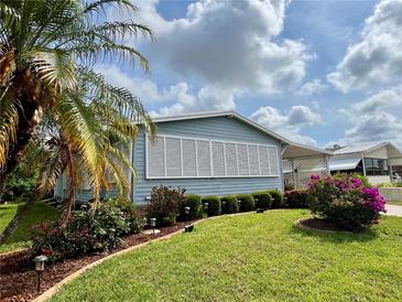 Charming home featuring manicured landscaping with lush greenery and colorful flowers, offering curb appeal at 857 Seabrooke Dr, Englewood, FL 34223