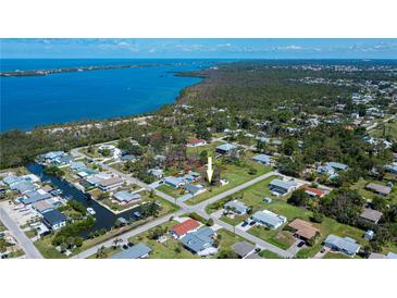 Wide aerial view of a neighborhood showcasing a waterfront community with lush surroundings and nearby ocean access at 900 Stewart St, Englewood, FL 34223