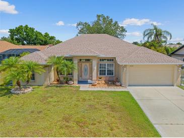 Charming one-story home featuring a well-maintained lawn and a welcoming entrance with decorative palm trees at 27038 San Jorge Dr, Punta Gorda, FL 33983