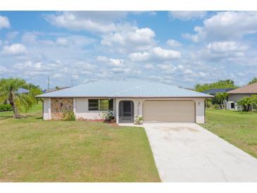 Charming single-story home featuring a clean driveway, neutral paint and a sturdy metal roof at 27050 Pelotas Dr, Punta Gorda, FL 33983