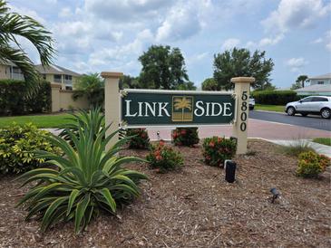 Welcoming Linkside community sign with lush landscaping and a vibrant, well-maintained entrance at 5800 Sabal Trace Dr # 1201, North Port, FL 34287
