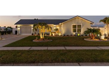 Charming home with a well-maintained front yard, featuring a lush lawn and landscaping, at dusk at 6286 Coniston St, Port Charlotte, FL 33981