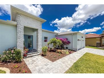 Stunning single-Gathering home featuring beautiful landscaping, a stone accent wall, and a charming entryway at 13284 Amaryllis Cir, Port Charlotte, FL 33981