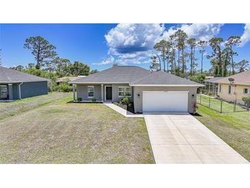 Beautiful single-story home features a gray exterior, well-maintained lawn, and an attached two-car garage at 18503 Ellen Ave, Port Charlotte, FL 33948