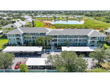 Well-maintained condo building with lush landscaping, covered parking, and a serene lake view in a desirable community at 2160 Heron Lake Dr # 201, Punta Gorda, FL 33983