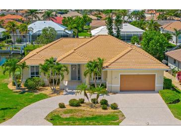 Well-maintained home showcasing a beautiful driveway, lush landscaping, and a warm, inviting facade at 2719 Mayaguana Ct, Punta Gorda, FL 33950