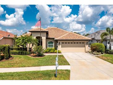 Charming single-story home featuring a tile roof, well-manicured lawn, and an American flag at 2913 Royal Palm Dr, North Port, FL 34288