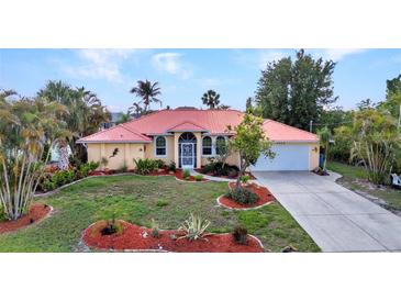 Charming single-Gathering home with a red roof, well-kept lawn, and tropical landscaping at 3058 Curry Ter, Port Charlotte, FL 33981