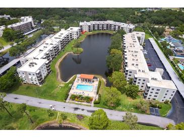 Scenic aerial view of condo community with a pool, lake and mature landscaping at 6070 80Th N St # 215, St Petersburg, FL 33709