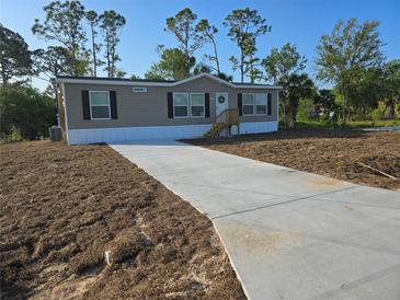 Charming home featuring a long driveway and well-manicured lawn at 15431 Orangeade Dr, Punta Gorda, FL 33955