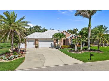 Charming home with a white tile roof, a spacious driveway, and beautifully manicured landscaping at 16232 Quesa Dr, Punta Gorda, FL 33955