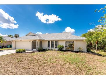 Charming single-story home with a well-maintained lawn and attached two-car garage at 18111 Lake Worth Blvd, Port Charlotte, FL 33948