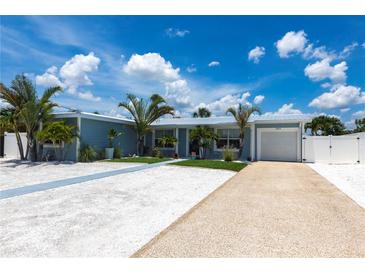 Charming single-story home with beautiful landscaping, driveway, and white picket fence at 21812 Edgewater Dr, Port Charlotte, FL 33952