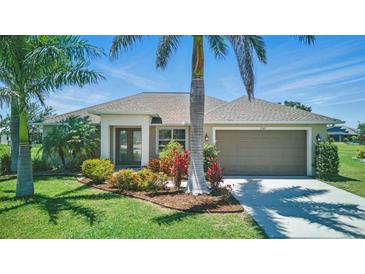 Charming single-story home featuring a well-manicured lawn, tropical landscaping, and a two-car garage at 7505 Carissa, Punta Gorda, FL 33955