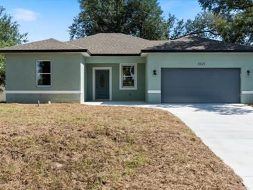 Charming one-story home with a grey door, gray two-car garage, and newly installed driveway at 8849 Attalla Ave, North Port, FL 34287