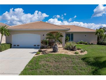 Charming single-story home with a two-car garage and lush landscaping, featuring a beautiful tile roof at 2526 Rio Plato Dr, Punta Gorda, FL 33950