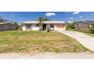 Charming single-story home featuring a light-colored exterior and a well-maintained front yard at 4035 Mcintire St, Port Charlotte, FL 33948