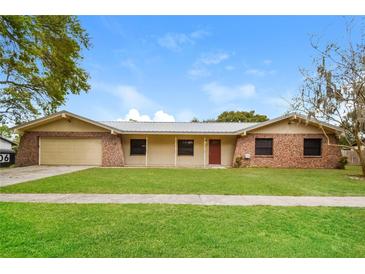 Charming single-story home featuring a metal roof, stone accents, and a well-maintained front yard at 406 Merlin Ct, Brandon, FL 33510