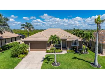 Beautiful single-story home with a well-manicured lawn, mature palm trees, and a two-car garage at 695 Macedonia Dr, Punta Gorda, FL 33950