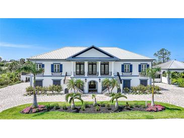 Stately two-story home with columns, mature landscaping, symmetrical design, and inviting curb appeal at 10161 Eagle Preserve Dr, Englewood, FL 34224
