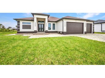 Stunning single-story home featuring a three-car garage and well-kept lawn at 15 Tournament Rd, Rotonda West, FL 33947