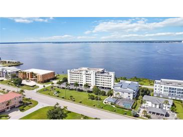 Expansive aerial view of a condo building on a scenic coastline with lush landscaping at 1500 Park Beach Cir # 2F, Punta Gorda, FL 33950