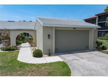 Charming home featuring a well-manicured lawn, lush landscaping, and an attached two-car garage at 2521 W Marion Ave # 912, Punta Gorda, FL 33950