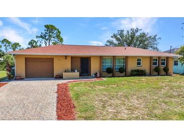 Charming single-story home with brick driveway, well-maintained lawn, and mature trees on a sunny day at 2626 Auburn Blvd, Port Charlotte, FL 33948