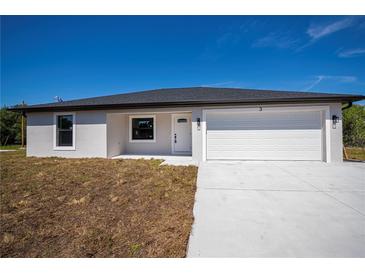 Newly built single-story home with a white exterior, garage, and a neatly laid driveway under a clear blue sky at 359 Salisbury St, Port Charlotte, FL 33954