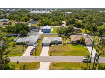An aerial view of single-Gathering homes boasting well-maintained lawns and mature trees enhancing curb appeal at 3886 Cincinnati St, North Port, FL 34286