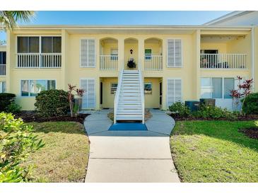 Charming two-story condo building with a well-maintained lawn and inviting stairway at 410 Cerromar S Cir # 240, Venice, FL 34293