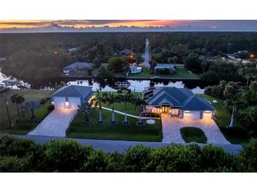 Beautiful sunset view of a waterfront home with lush landscaping and a private dock at 1025 Cheshire St, Port Charlotte, FL 33953